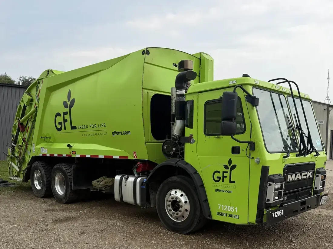 Freshly washed GFL Environmental refuse truck at a Central Illinois yard
